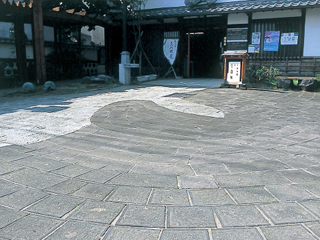 古い街並みが残る御所通りに面して、白壁の建物がしっとりした風情を漂わせます。2種類の石(なべた石・島崎石)をつかいわけ、流れを表現しています。